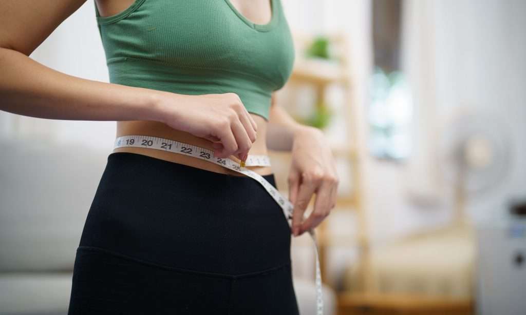 Asian healthy woman dieting Weight loss. Slim woman measuring waist