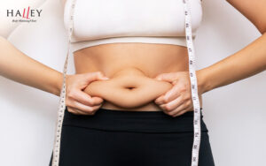 Person pinching excess body fat on their stomach