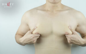 Man examining chest fat for gynecomastia reduction treatment.