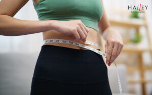 Woman measuring her waist for weight loss.