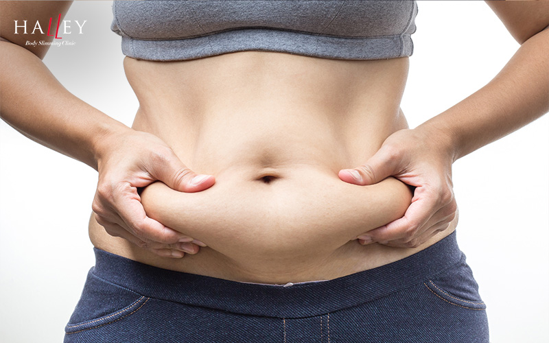 Halley Body Slimming Clinic | Weight Loss After Menopause: Managing Belly Fat and Body Changes Person pinching belly fat with both hands.