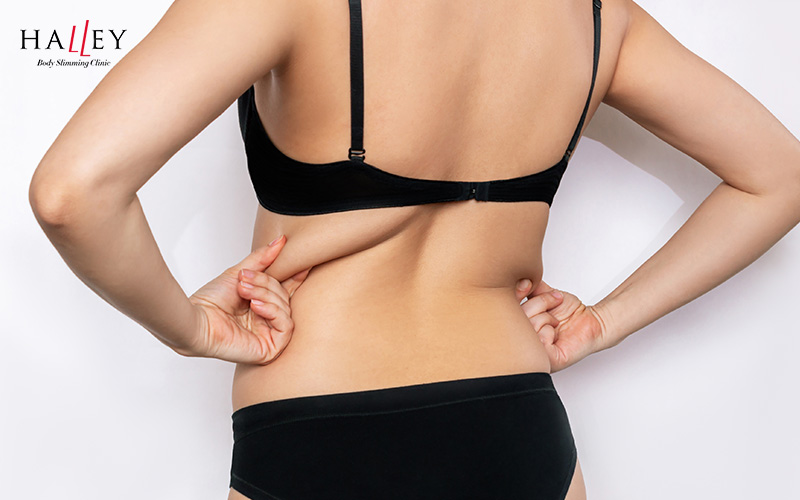 A woman with arms raised showcasing smooth underarms and toned upper body